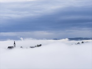 Church tower rises out of the morning mist, Frauenberg pilgrimage church, near Leibnitz, Styria,