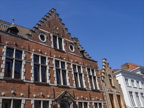 Historic gothic building with brick facade and pointed dormer windows under a clear blue sky,