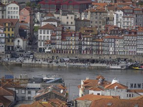 Panorama of a city with historic buildings and a river in the foreground, The old town of Porto on