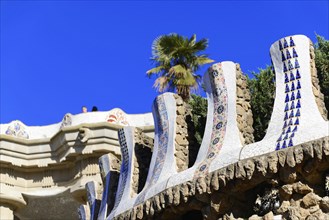 Mosaic-decorated architecture and palm trees against a clear sky, Barcelona, Catalonia, Spain,