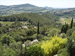 A vast green landscape with hills and forests under a clear blue sky, Provence, le Castellet,