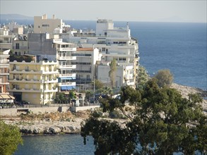 Multi-storey buildings along the coast with a view of the sea and trees in the foreground, Ancient