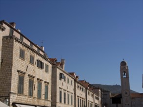 Historic old town with stone buildings and a clock tower under a clear blue sky, the old town of