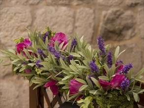 Flower decoration with lavender and pink flowers against a stone background, the old town of