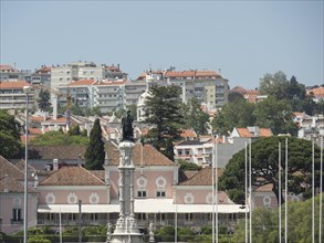 View of urban neighbourhood with old and modern buildings, greenery, clear sky, Lisbon, Portugal,