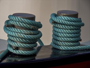 Close-up of two blue-wrapped mooring lines on a boat, historic houses in Hoorn and ships in the