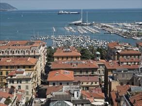 Harbour area with many boats and yachts, surrounded by a town with red roofs by the sea, Bari,