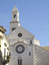 An imposing church with a high bell tower against a clear sky, The city of Bari on the