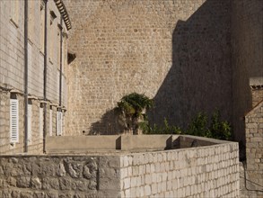 Stone walls and a small building with shadows and lots of texture, the old town of Dubrovnik with