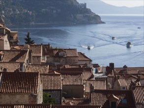 View over the red roofs of the city to the calm sea and boats, the old town of Dubrovnik with