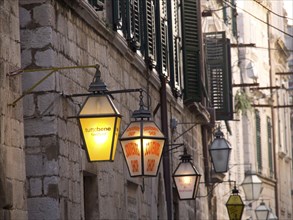 Narrow old town street with illuminated lanterns and stone walls, the old town of Dubrovnik with