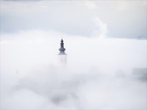 Church tower rises out of the morning mist, Frauenberg pilgrimage church, near Leibnitz, Styria,