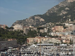 Panorama of a busy harbour with many yachts and a city nestled in the mountains, monaco on the