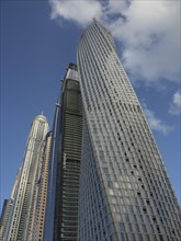 Modern skyscrapers with glass facades in front of a blue sky with some clouds, dubai, arab emirates