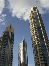 Three modern skyscrapers in front of a blue sky with few clouds on a sunny day, dubai, arab