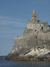A historic church on the cliffs by the sea with impressive stone architecture and a clear blue sky,