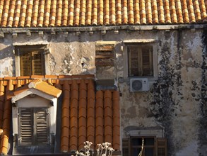 Old buildings with red tiled roofs and closed shutters, partially dilapidated facades, the old town