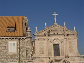 Historic church buildings with crosses and tiled roofs against a blue sky, the old town of