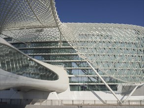 Building with a futuristic, curved glass facade and a clear sky behind it, Abu Dhabi, United Arab