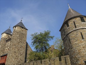 Historic castle with impressive stone towers and trees under a clear sky, Maastricht, Netherlands