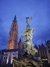 Artistic statue and church tower by night in a picturesque cityscape, the historic market square of