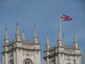 Gothic towers with Union Jack flag in front of blue sky in Great Britain, London, England, Great