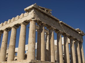 Ancient temple with doric columns in the sunlight under a blue sky, ancient columns in front of a