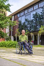 Vertical full length portrait of a proud adult caucasian man with disability in the university