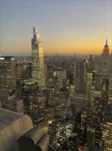 Cityscape during sunset with a multitude of illuminated skyscrapers, the skyline of new york with