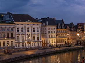 Illuminated historic buildings at dusk along the waterfront in Bruges, historic buildings with