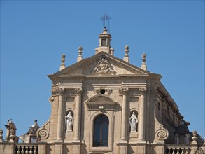 Front view of a church with ornate statues and a cross on the roof, palermo in sicily with an