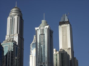 View of several skyscrapers with modern design in front of a clear blue sky, dubai, arab emirates