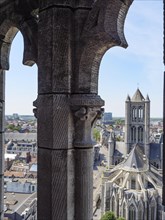 View through a Gothic arch onto a cathedral and the cityscape behind it on a sunny day, medieval