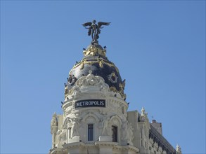 Building detail with magnificent dome and sculpture, all under a clear blue sky, Madrid, Spain,