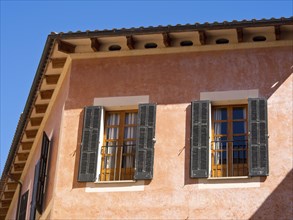 Close-up of a house with open shutters and a balcony in a summer atmosphere, palma de Majorca with