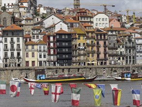 View of an old town with colourful houses on the banks of a river, decorated with flags, small