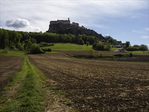 Clods of earth in farmland, Riegersburg Castle in the background, near Riegersburg, Styria,