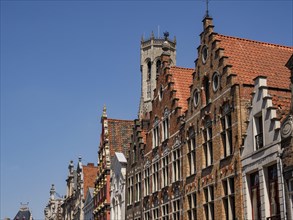 Detail of buildings with decorated towers and roof tiles under a clear sky, historic house facades
