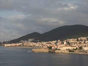 Coastal town on the waterfront with hills in the background in the evening light, Corsica, ajaccio,