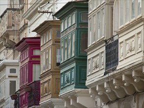 Row of colourful, traditional balconies on house facades in a town, Valetta, Malta, Europe