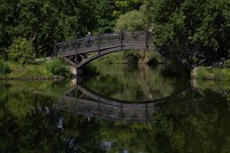 Elderly woman on wooden bridge, north bridge, Johannaparkteich, Johannapark, Leipzig, Saxony,