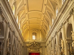 Magnificent interior architecture of a church with statues, arches and rich decor, flooded with