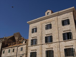 Multi-storey building with green shutters against a clear sky, the old town of Dubrovnik with