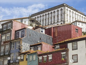 Multi-storey, colourful buildings with tiled roofs in an old town with a white historic building in