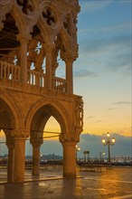 Beautiful Ducal Palace with Arches and Street Lamps and Gondola in San Marco Square in Sunset in