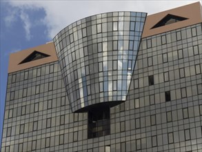 Architecturally modern building with many windows and a glass facade that reflects the sky, Lisbon,