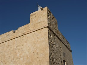 Historic sand-coloured stone fortress under a blue sky, Valetta, Malta, Europe