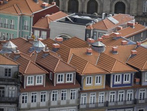 Colourful old town houses with tile-red roofs and several skylights in a densely built-up area, old