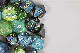 Blue and green roleplaying game RPG dice on side of gray background with blank copy spac
