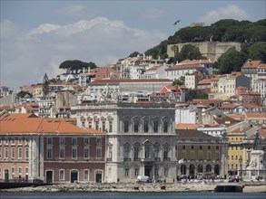 Historic buildings on a hill along the riverside under a blue sky in Lisbon, Lisbon, Portugal,